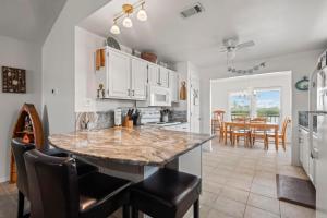a kitchen with a large island in a kitchen with chairs at Lucky Enough in Gulf Shores