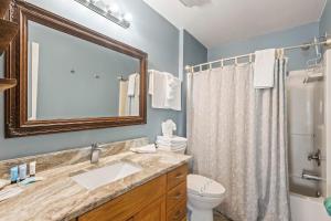 a bathroom with a sink and a toilet and a mirror at Lucky Enough in Gulf Shores +28 photos