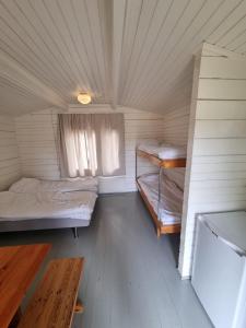 a small room with two beds and a window at Kirjurin Leirintä in Pori