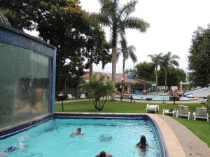 - un groupe de personnes se baignant dans une piscine dans l'établissement Cantinho Aconchegante Morada do Sol, à Piratuba