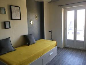 a bedroom with a large yellow bed with a window at Entre châteaux et vignobles, au bord de la Loire in Montlouis-sur-Loire