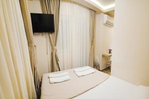 a hotel room with a bed and a flat screen tv at Villa Montemaris Budva in Budva