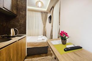 um pequeno quarto com uma cama e uma mesa com flores em Villa Montemaris Budva em Budva