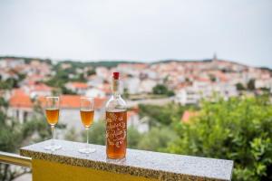 a bottle of wine and two wine glasses on a ledge at Sunce 1 in Vrbnik