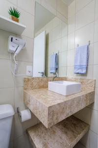 a bathroom with a sink and a toilet at Curta Praia do Quilombo - Lunata in Penha