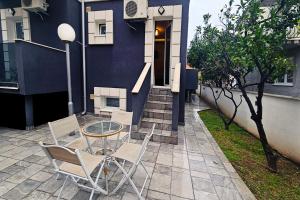 a patio with a table and chairs in front of a house at Villa Montemaris Budva in Budva