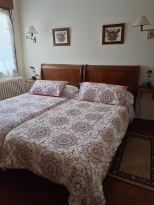 a bedroom with a bed with a blanket and pillows at Casa Rural Oihan - Eder in Espinal-Auzperri