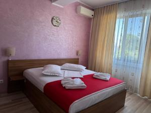 a bedroom with a bed with towels on it at Hotel Mihaela in Mamaia +34 photos