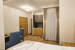 a room with a bed and a desk and a kitchen at Villa Montemaris Budva in Budva