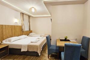 a hotel room with a bed and a table and chairs at Villa Montemaris Budva in Budva