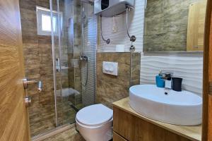 a bathroom with a toilet and a sink and a shower at Villa Montemaris Budva in Budva