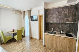 a kitchen with a sink and a table in a room at Villa Montemaris Budva in Budva