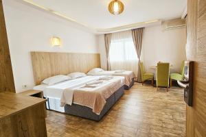 um quarto de hotel com duas camas e uma televisão em Villa Montemaris Budva em Budva