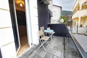 a patio with a table and chairs on a balcony at Villa Montemaris Budva in Budva