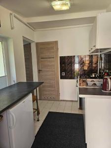 a kitchen with white cabinets and a black counter top at Apartament i domki wakacyjne w uroczym zakątku Ustki in Ustka