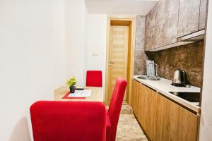 a kitchen with a table and two red chairs at Villa Montemaris Budva in Budva