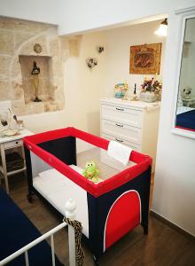 sypialnia dla dzieci z łóżeczkiem dziecięcym z zabawką w obiekcie Casa Donnalby w mieście Monopoli
