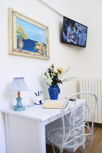 białe biurko z lampą i wazonem kwiatów w obiekcie Casa Donnalby w mieście Monopoli
