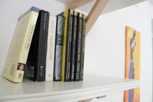 a row of books sitting on a shelf at Casa Donnalby in Monopoli