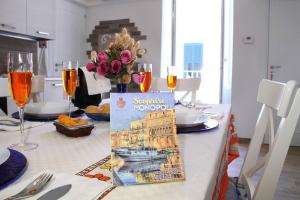 a table with glasses of wine and a vase of flowers at Casa Donnalby in Monopoli