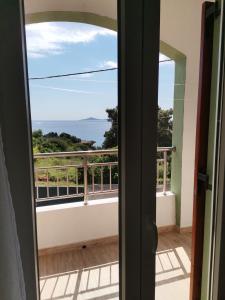 a door leading to a balcony with a view of the ocean at Litsa Studios in Patitiri