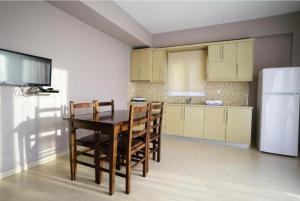 cocina con mesa, sillas y nevera en Apartments Vila Emiliano, en Borsh