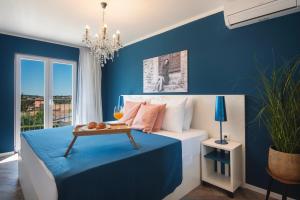 a bedroom with blue walls and a bed with a table at Vinkuran Residence - Adults Only in Pula