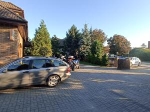 馬爾堡的住宿－Dom Turysty Na Skarpie，停在摩托车旁边的街道上的汽车