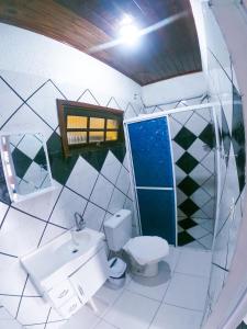 a bathroom with a toilet and a sink at Pousada Maravista in Cananéia
