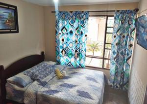 1 dormitorio con cama y ventana en Residencial Moroni - Alojamiento en Cochabamba, en Cochabamba