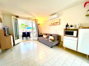 ein Wohnzimmer mit einem Sofa und einer Mikrowelle in der Unterkunft Modern, 2 bedrooms, Aircon, pool & fiber optic in a quiet, private gated domain 5kms to St Tropez in Cogolin