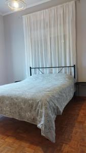 1 dormitorio con 1 cama con colcha blanca en Central Village House, en Lépoura
