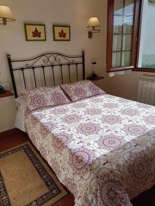 a bedroom with a bed with a pink and white comforter at Casa Rural Oihan - Eder in Espinal-Auzperri