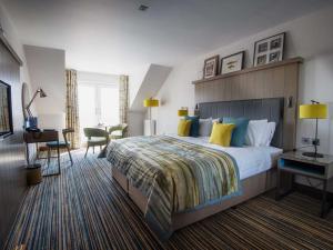 a hotel room with a large bed and a desk at The Waterside Hotel in Seamill