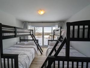two bunk beds in a room with a window at La Vue - Mountain Top Cottage in Notre-Dame-de-la-Salette