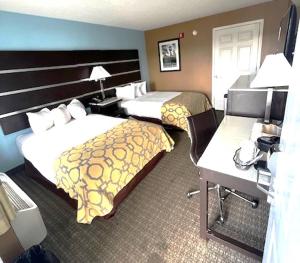 ein Hotelzimmer mit 2 Betten und einem Schreibtisch in der Unterkunft Baymont by Wyndham Gaffney in Gaffney