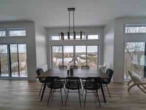 a dining room with a large wooden table and chairs at La Vue - Mountain Top Cottage in Notre-Dame-de-la-Salette