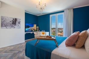 プーラにあるVinkuran by Bura Hotels - Adults Onlyの青い壁のベッドルーム1室、ベッド1台(テーブル付)