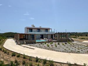 a house with a garden and a swimming pool at Villa Milan 1 mit Padelplatz in Kos Town