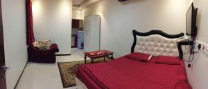 1 dormitorio con 1 cama roja y 1 silla en fort House en Amán
