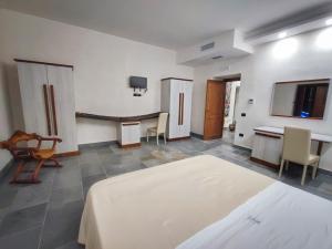 um quarto com uma cama, uma mesa e cadeiras em Palazzo Iaquinta - Luxury Rooms & Wellness em Cicerale