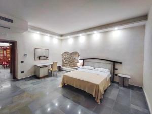 um quarto com uma cama, uma secretária e uma mesa em Palazzo Iaquinta - Luxury Rooms & Wellness em Cicerale