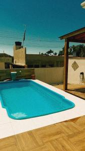 uma grande piscina azul num piso de madeira em Suítes Moreira em Penha