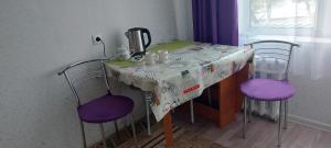 a table with two purple chairs and a table cloth on it at Уютная 1 комн квартира посуточно в Балхаше Жидебай Батыра, 11 in Balqash +10 photos