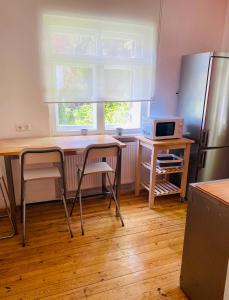 慕尼黑的住宿－Wohnung mit Charme，厨房配有桌椅和冰箱。