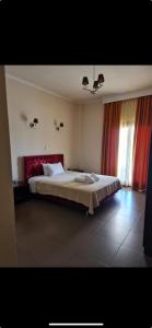 1 dormitorio con 1 cama grande y cortinas rojas en Faraggi Hotel, en Simvolí