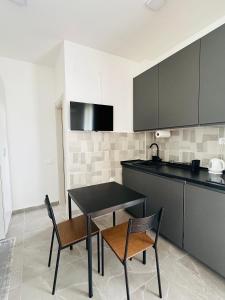 a kitchen with a black table and two chairs at Cozy studio Bečići in Becici