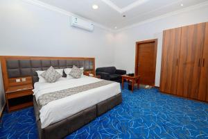 una camera d'albergo con letto e sedia di الماسم للأجنحة المخدومة- الملك فهد a Riyad