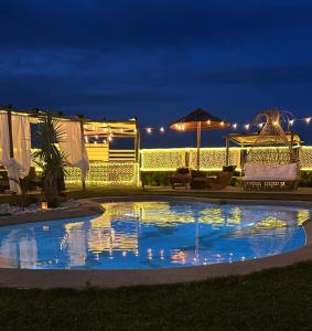 a swimming pool at night with lights on a resort at Essenziale in Castell’Anselmo
