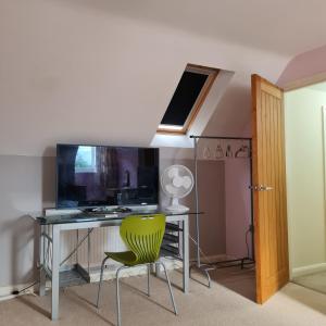 a room with a desk and a green chair at Large Double Room with Ensuite and double shower - Homestay in Bishops Frome